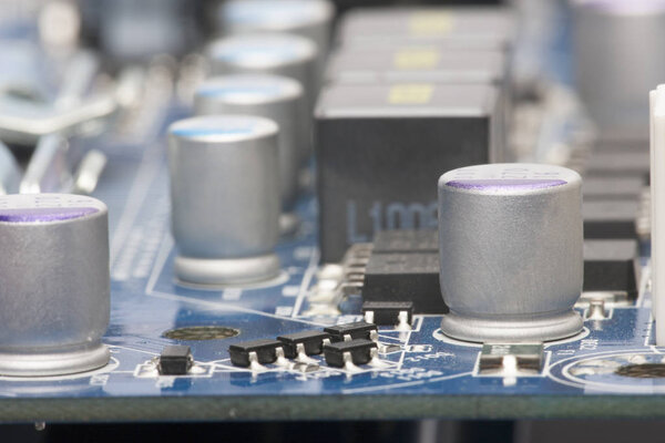 Electronic board. The board features elements: chips, diodes, capacitors, chokes. Shallow depth of field. Can be used as a background. There is a place for an inscription.