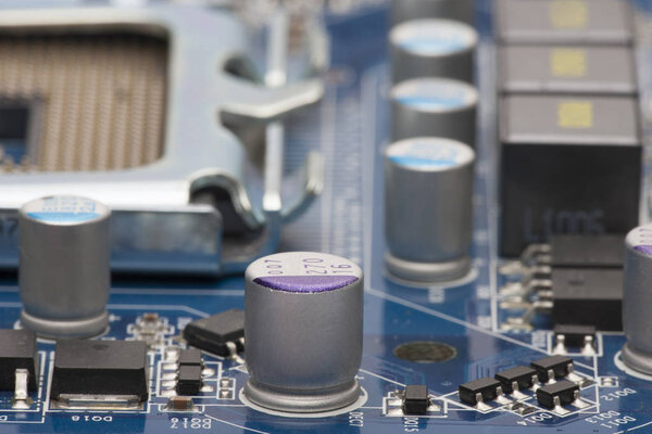 Electronic board. The board features elements: chips, diodes, capacitors, chokes. Shallow depth of field. Can be used as a background. There is a place for an inscription.