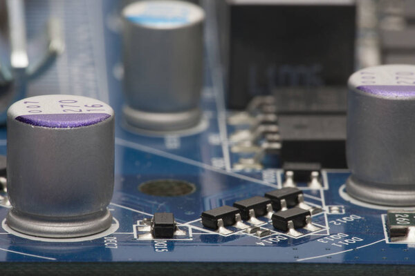 Electronic board. The board features elements: chips, diodes, capacitors, chokes. Shallow depth of field. Can be used as a background. There is a place for an inscription.