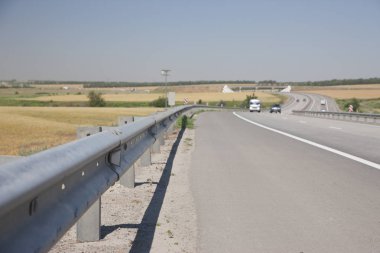 Otoyol arka plan bulanık çitin solunda, güvenlik kavramı uygun olarak donatılmış modern bir otoyol arabalar geliyor