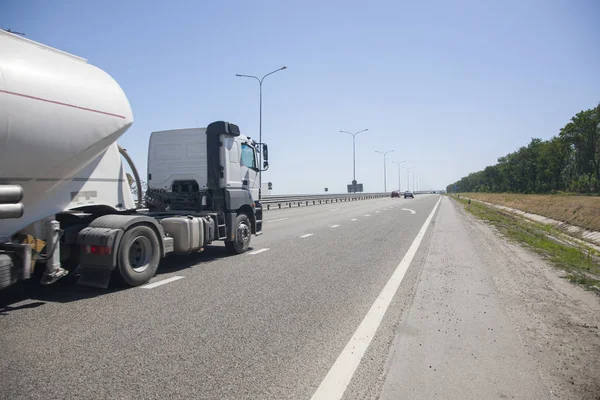 A truck with a trailer is driving along the highway A modern highway, equipped in accordance with the concept of security