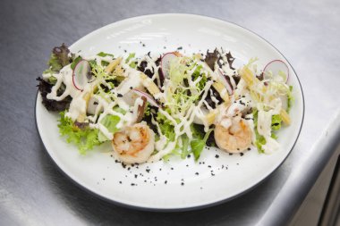 Yakın çekim deniz ürünleri salatası hazırlama aşçılar