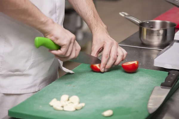 The hands of the chef preparing a salad of greens Close-up