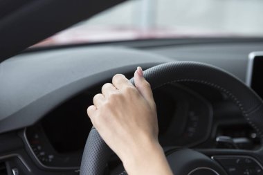 Bir salon arabada gidonun üzerine şık bir manikür bir kızla ele oturuyor. Yakın çekim