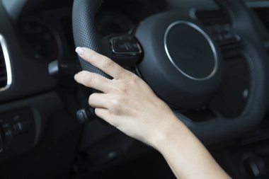 Bir salon arabada gidonun üzerine şık bir manikür bir kızla ele oturuyor. Yakın çekim