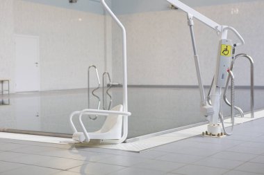 Engelliler havuza iniş için kaldırın. Bulanık bir arka plan üzerinde bir yüzme havuzu görülür