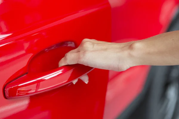 Mujer mano en abrir el nuevo fondo rojo de la puerta del coche —  Fotos de Stock