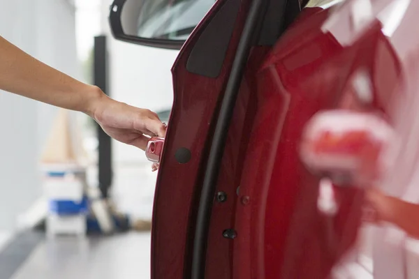 Mujer mano en abrir el nuevo fondo rojo de la puerta del coche —  Fotos de Stock