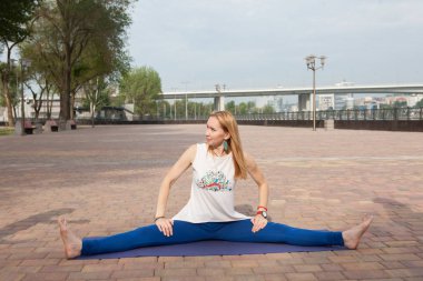 Güzel kadın Upavistakonasana poz yoga sınıf park ortak eğitimler yoga öğretmenler için yoga pratik kadınların grup yapıyor