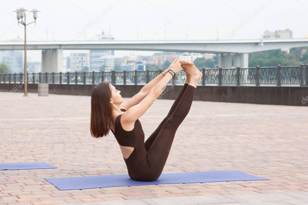 Beautiful woman doing Vriksasana pose on yoga class Group of women practicing yoga in park Joint trainings for yoga teachers