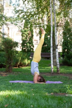 Yoga açık pratik. Ağaçlar, dağlar ve içinde belgili tanımlık geçmiş sun ray ile Yoga uygulamak