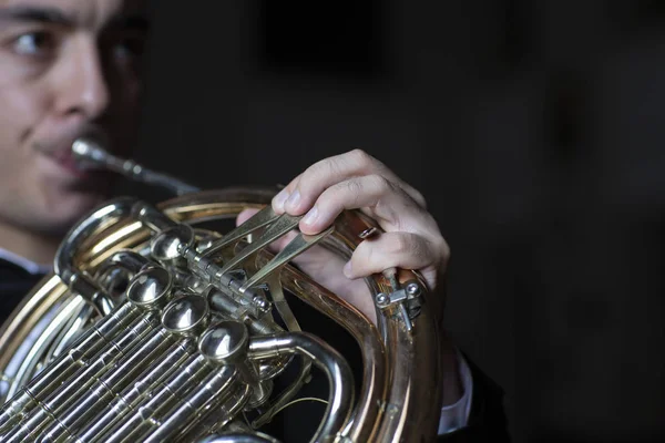 French horn instrument. Hands playing horn player close up