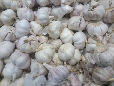 Sebze pazarının tezgahında sarımsak var. Yakın çekim ve raflardaki taze sebzelerin üst görüntüsü. Salatalar ve hafif atıştırmalıklar için malzemeler. Çiftlikten hasat et. Yumuşak odaklanma. Yakın plan.