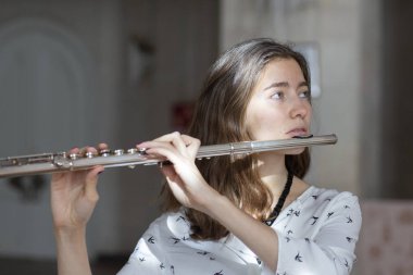 Genç güzel girlr yakın çekim tür portresi bir flüt üzerinde oynarken poz güzel bir kadın