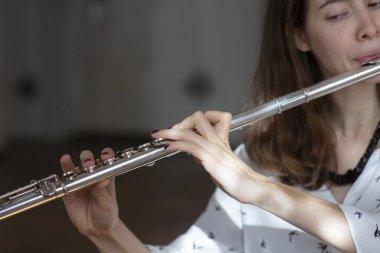 Konser sırasında kızın elinde bir flüt flüt çalarken poz güzel bir kadın. Genç güzel girlr yakın çekim tür portresi