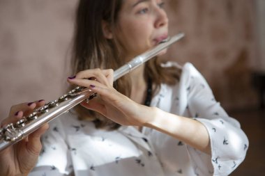 Konser sırasında kızın elinde bir flüt flüt çalarken poz güzel bir kadın. Genç güzel girlr yakın çekim tür portresi