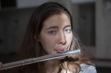 Genç güzel girlr yakın çekim tür portresi bir flüt üzerinde oynarken poz güzel bir kadın