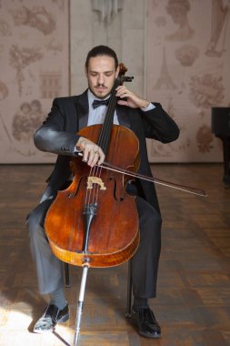 Çello çalan bir genç adam. Yakın çekim çellist portresi