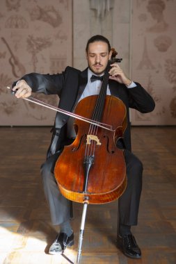 Çello çalan bir genç adam. Yakın çekim çellist portresi