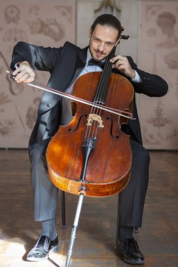 Çello çalan bir genç adam. Yakın çekim çellist portresi