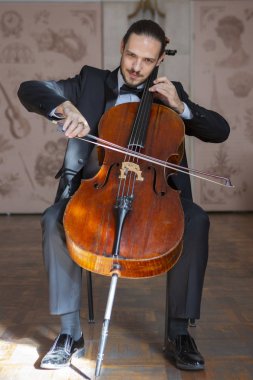 Çello çalan bir genç adam. Yakın çekim çellist portresi