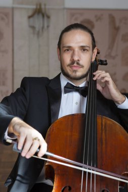 Çello çalan bir genç adam. Yakın çekim çellist portresi