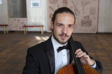 Çello çalan bir genç adam. Yakın çekim çellist portresi