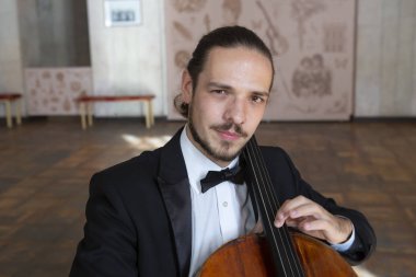 Çello çalan bir genç adam. Yakın çekim çellist portresi