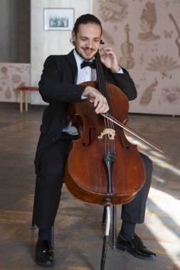 Çello çalan bir genç adam. Yakın çekim çellist portresi
