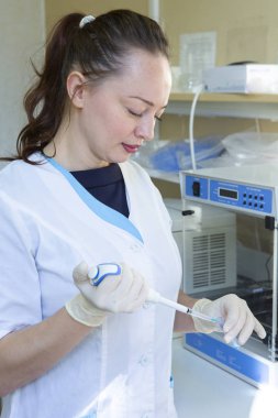 Genç bilim adamı hazırlama ve mikroskop slaytlar araştırma laboratuarında analiz modern biyolojik laboratuvar genç kadın araştırma bilim adamı çalışır.