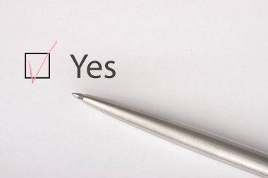 Evet - checkbox metal kalem ile beyaz kağıt üzerinde bir onay işareti ile. Denetim listesi kavramı. Yakın çekim