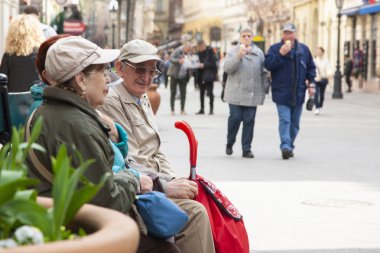Budapeşte, Macaristan - 6 Nisan 2018: Olgun karı koca birlikte şehrin bankta otururken tadını çıkarıyor. Tür