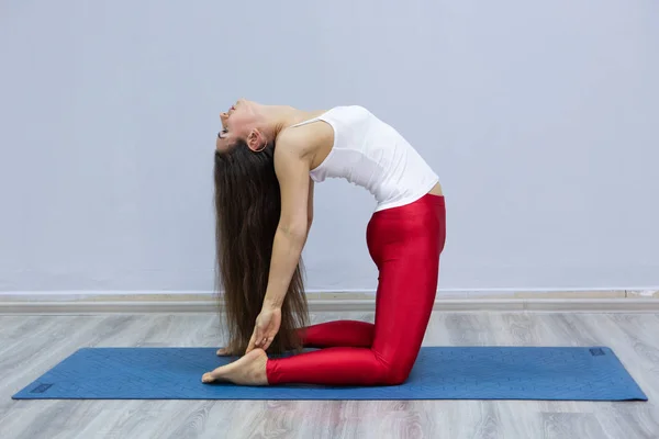 Genç kadın arka planda bir kentsel tür Yoga uygulamak