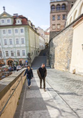 Prag, Çek Cumhuriyeti - 15 Şubat 2017: Genç çift yürüyüş boyunca kentsel sokak A özel lens optik eksen yatırmak için kullanıldı. Tür