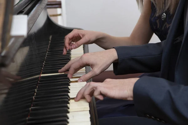 closeup musician hands playing piano on piano keyboard. abstract musical background