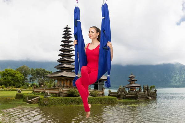 Young woman practicing fly yoga asana outdoors. Health, sport, yoga concept Limited depth of field