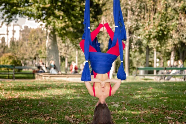 Young woman practicing fly yoga asana outdoors. Health, sport, yoga concept Limited depth of field