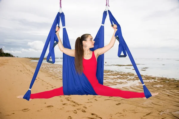 Aerial yoga or Anti-gravity yoga. Young woman practicing fly yoga asana outdoors