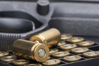 Beyaz arka plan üzerinde izole tabanca ve mermileri yakın çekim. MKE yayılmasını sınırlayan kavramı.