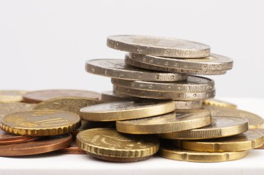 Farklı konumlarda birbirlerine yığılmış Euro paralar. Seçici odak