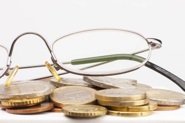 Farklı konumlarda birbirlerine yığılmış Euro paralar. Seçici odak