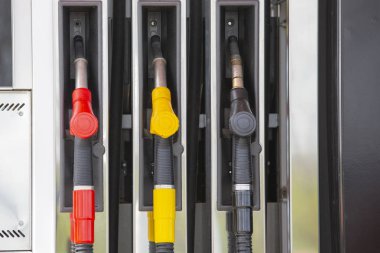 Benzin ve dizel yakıtta yakın çekim yakıt memeleri. Benzin istasyonu pompası. Bir arabada benzinle benzin ikmali, elinde meme tutan bir adam. Sınırlı alan derinliği.