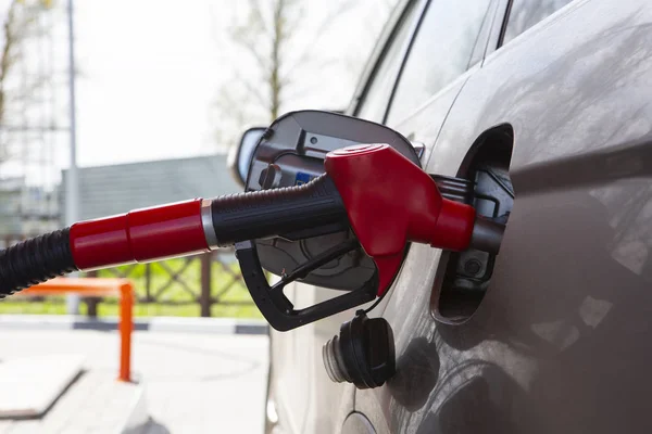 Fill the car with fuel. The car is filled with gasoline at a gas station. Gas station pump. Man refueling gasoline with fuel in a car, holding a nozzle. Limited depth of field. Blurred image — Stock Photo, Image