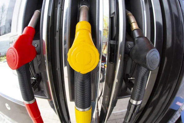 Close-up fuel nozzles on petrol and diesel fuel. Gas station pump. Man refueling gasoline with fuel in a car, holding a nozzle. Limited depth of field. — Stock Photo, Image