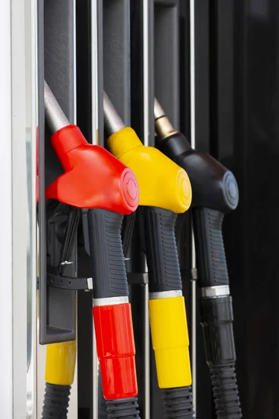Close-up fuel nozzles on petrol and diesel fuel. Gas station pump. Man refueling gasoline with fuel in a car, holding a nozzle. Limited depth of field.
