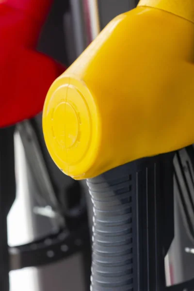 Close-up fuel nozzles on petrol and diesel fuel. Gas station pump. Man refueling gasoline with fuel in a car, holding a nozzle. Limited depth of field.
