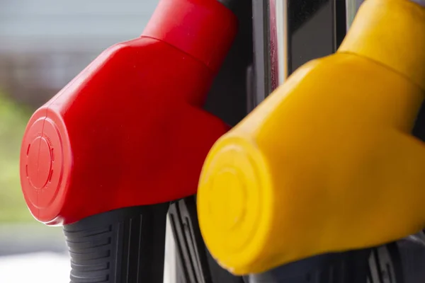 Close-up fuel nozzles on petrol and diesel fuel. Gas station pump. Man refueling gasoline with fuel in a car, holding a nozzle. Limited depth of field. — Stock Photo, Image