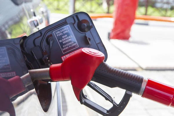 Llena el auto con combustible. El coche está lleno de gasolina en una gasolinera. Bomba de gasolinera. Hombre repostando gasolina con combustible en un coche, sosteniendo una boquilla. Profundidad de campo limitada. Imagen borrosa — Foto de Stock