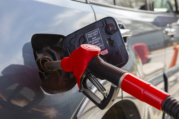 Fill the car with fuel. The car is filled with gasoline at a gas station. Gas station pump. Man refueling gasoline with fuel in a car, holding a nozzle. Limited depth of field. Blurred image — Stock Photo, Image