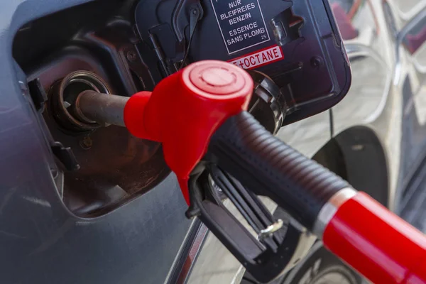Fill the car with fuel. The car is filled with gasoline at a gas station. Gas station pump. Man refueling gasoline with fuel in a car, holding a nozzle. Limited depth of field. Blurred image — Stock Photo, Image